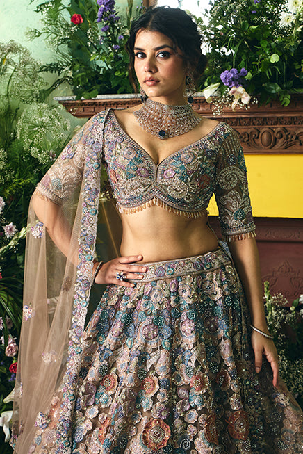 Woman in a traditional embroidered outfit with floral patterns in an outdoor setting.